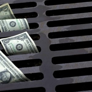 US Dollar bills down the street drain